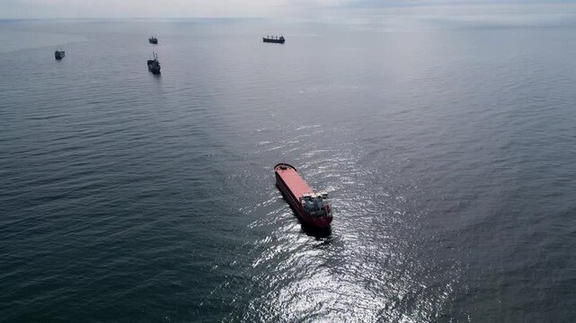 Aerial view of cargo ships anchored in the open sea at sunny day