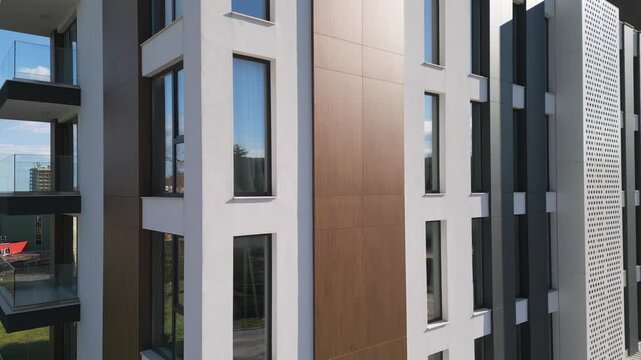 Aerial tilt up of modern residential building facade with windows and balconies