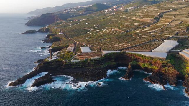 Aerial View of La Fajana Lighthouse and Coastal Banana Plantations at Sunrise; Maritime Infrastructure, Industrial Agriculture, and Solar Azimuth, La Palma, Canary Islands, Spain
