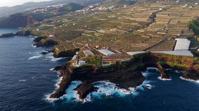 Aerial View of La Fajana Lighthouse and Coastal Banana Plantations at Sunrise; Maritime Infrastructure, Industrial Agriculture, and Solar Azimuth, La Palma, Canary Islands, Spain