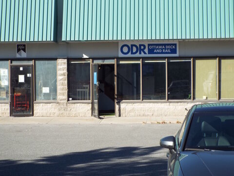 Nepean, Ontario, Canada &ndash; July 27, 2025: The storefront for "Ottawa Deck and Rail" at 77 Auriga Drive features a teal metal roof and large glass windows.