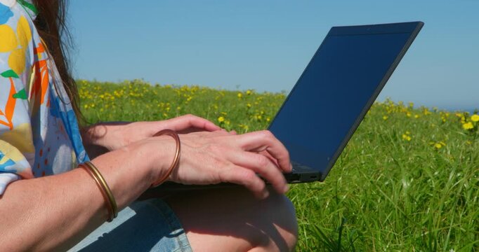 Laptop Lifestyle:  A person immersed in work, fingers dancing across the keyboard, embraces the modern age of flexible work. the beauty of the outdoors.