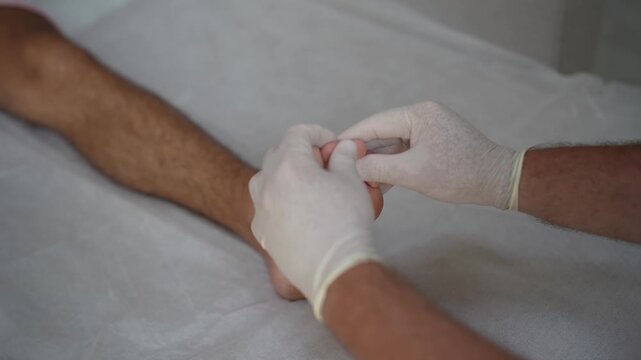 Doctor examining male foot during medical checkup. Close-up video of foot inspection and physical assessment in clinic, healthcare and diagnosis concept.