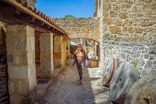 Krka Waterfalls National Park, Croatia: Woman walking through stone archway with millstones