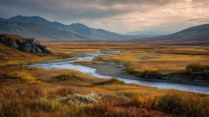 Fototapeta premium Alaskan North Slope autumn scenery: expansive tundra, meandering river, and an industrial pipeline