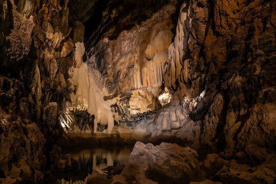 Altinbesik Cave with an underwater lake, illuminated with colored lights. Antalya, Turkey.