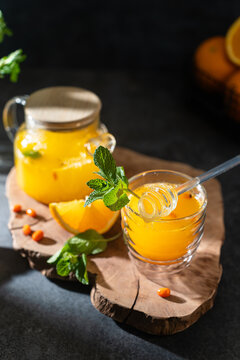 Sea buckthorn beverage with orange and ginger on wooden board, ideal for autumn drinks, wellness recipes, and culinary displays, immune-boosting tea, sbiten menu, recipe