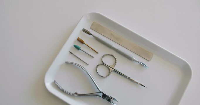 Sterile professional manicure tools on tray prepared for nail care procedure at beauty salon. Necessary tools for making clients nails well-groomed and ready for covering with polish.