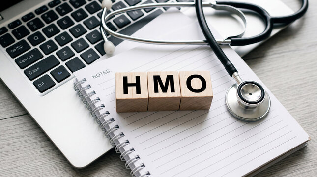 Medical stethoscope on a desk with laptop and notebook with HMO blocks