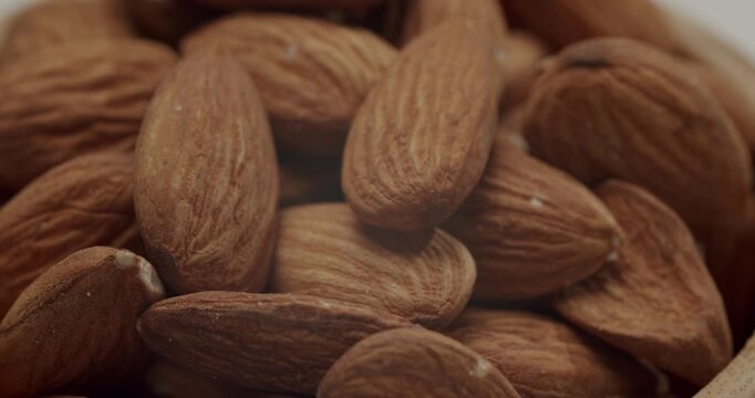 Natural raw almond nuts rotating in a close-up view, showcasing the rich texture and details of the healthy, organic superfood, representing nutritious eating and vegan dieting concepts
