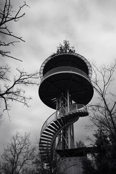 V&aacute;rhegyi Lookout Tower in Fonyod, Hungary, rising above leafless trees under an overcast sky, showing striking metal structure and a dramatic Balaton region atmosphere