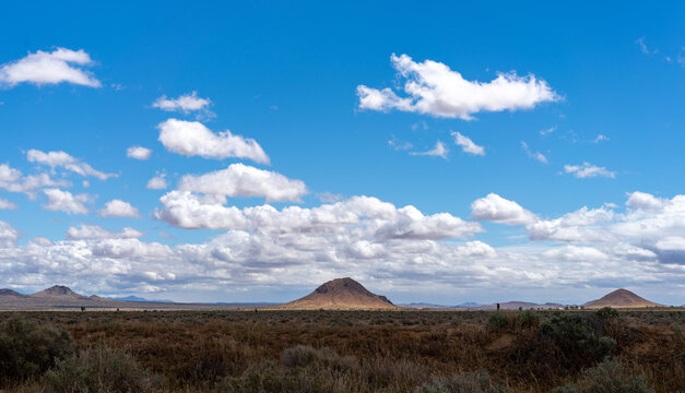 Twin Buttes in the Mojave Desert Beneath Blue Skies and Passing Clouds