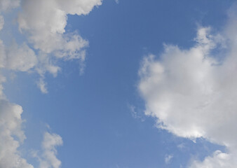 Obraz premium Blue sky with large soft clouds forming natural frame, minimal cloudscape background with open copy space and serene atmosphere