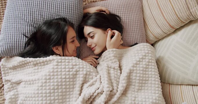 Couple of women hug each other warmly and relax at home in the bedroom. Lgbt and lesbian women at home. Embrace and holding each other. Friendship concept. Lifestyle and relationships. Couple,