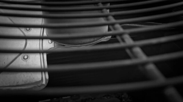 close-up view of a fan blade moving in an air conditioning unit system protected by a metal grill. seasonal video. hvac background banner. motion
