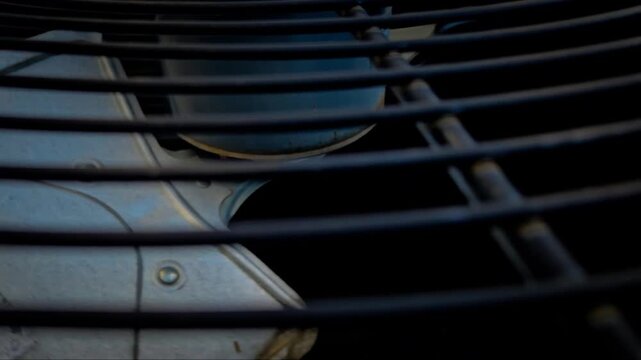 a fan blade spinning in an older air conditioning unit system protected by a metal grill. seasonal video. hvac background banner. motion