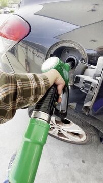 Echar gasolina y repostar con manguera y llenar tanque dep&oacute;sito de coche en surtidor de gasolinera self service estaci&oacute;n de servicio de carburante sin plomo y di&eacute;sel 
