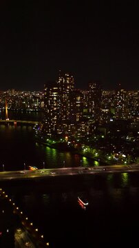 佃のマンション群と隅田川と佃大橋と屋形船の夜景