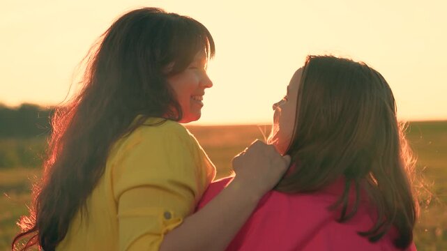 Happy family strolling on lawn, enjoying nature. Mom child daughter hug in sunny park. Happy girl hugs mother outdoors. Teenage girl hugs mom in summer park. Carefree childhood mommy daughter. Travel