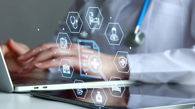 Doctor working on a laptop with medical icons and documents on the screen in a modern office setting.