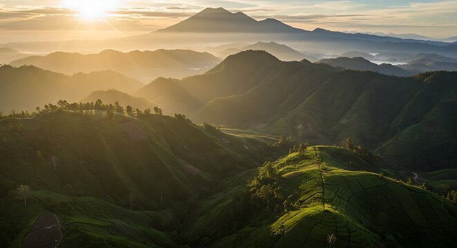 Scenic mountain range landscape at sunrise with layered peaks and bright sunlight
