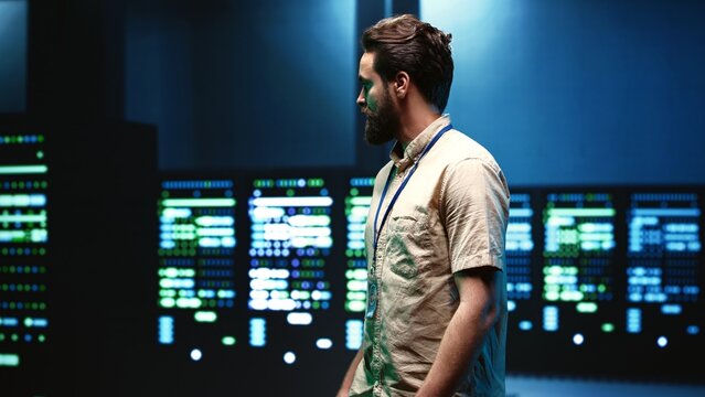 Engineer walking in server room housing advanced data storage infrastructure storing massive datasets, supporting critical workloads requiring IT equipment to run at high power densities