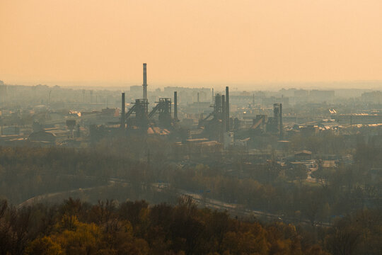 Industrial Fog Scene. Heavy Industry Silhouettes Beneath Muted Golden Light And Thick Emissions