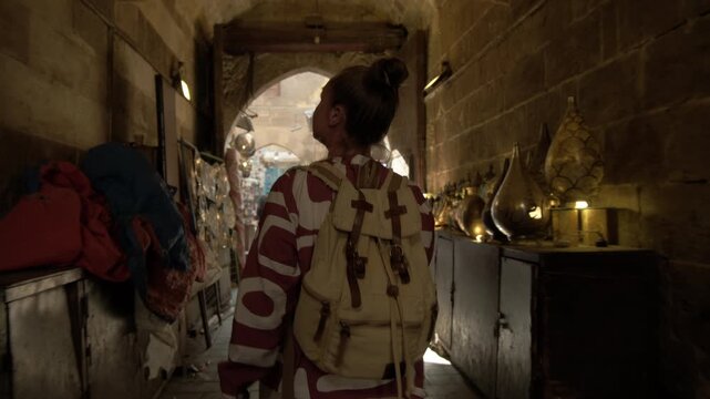 Caucasian woman tourist walking in picturesque arched passage at Khan El Khalili Bazaar in Cairo