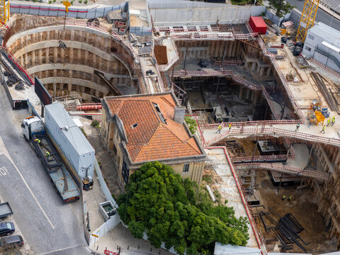Aerial view of the Monte Estoril construction site featuring deep excavation, concrete foundations, and workers near a historic building in Estoril, Lisbon, Portugal.
