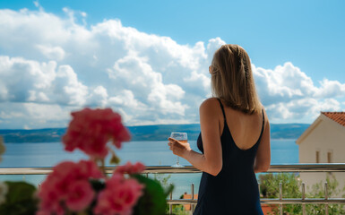 Obraz premium Woman admiring sea view from resort balcony.