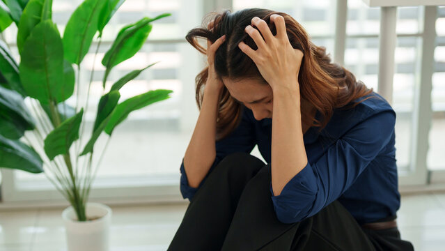 A Moment of Stress: An individual grapples with a moment of emotional distress, hands clasped to their head as they navigate the complexities of their inner world. 