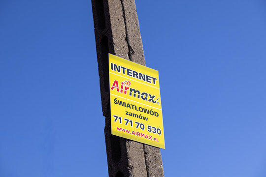 Szklarska Poreba, Poland - December 18, 2025: Airmax brand advertising sign prominently displayed on a concrete utility pole against a vibrant blue sky