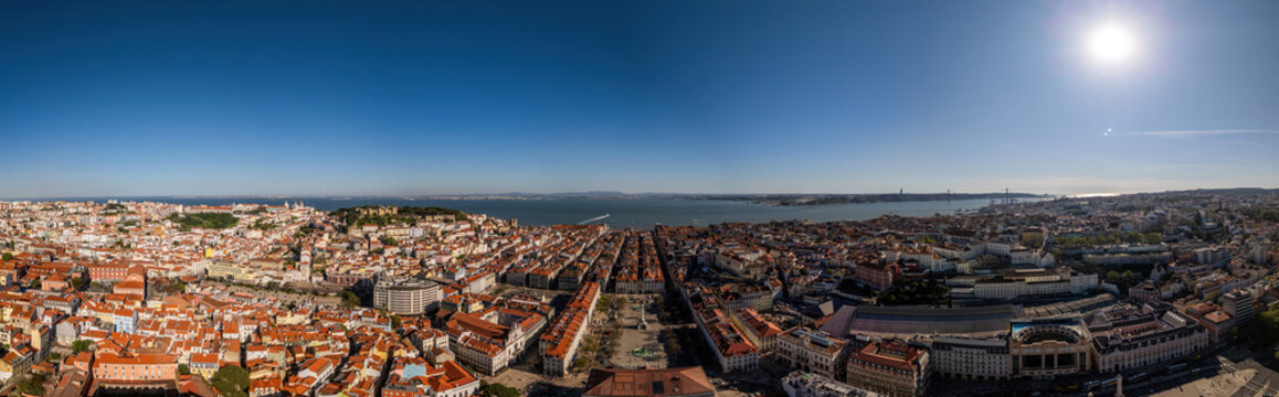 Aerial view of the historic Baixa district, Rossio Square, and the Tagus River under a clear blue sky in Lisbon, Lisbon, Portugal.