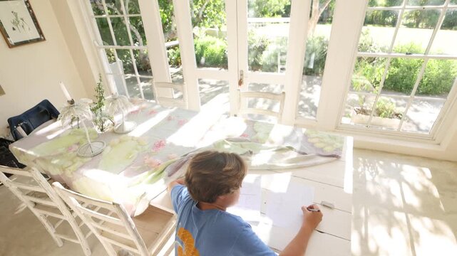 12 year old boy doing homework on kitchen table
