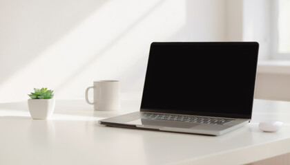 Fototapeta premium A laptop sits on a white desk next to a plant and coffee mug.
