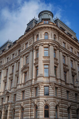 Fototapeta premium a majestic neoclassical corner building in Stockholm featuring ornate stone facades and a dark mansard roof.