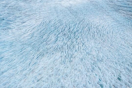 Aerial view of Hoffellsjokull glacier with deep blue crevasses and textured ice ridges in Hofn, Sveitarfelagid Hornafjordur, Iceland.