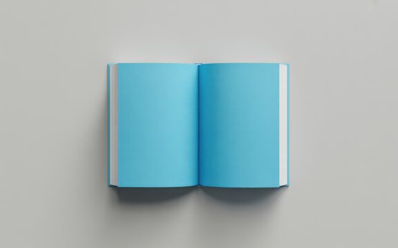 An open blue book lies on a plain gray surface indoors.
