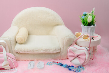 Stylish newborn digital backdrop with a cream sherpa sofa on pink fur. Features trendy heart-shaped purses, sunglasses, and a floral plant for a chic look. © Munif Rifa'i