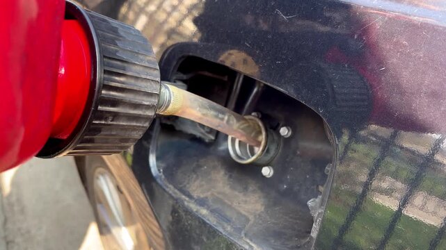 Refueling filling car benzine gasoline fuel at gas station from canister.fuel nozzle into automobile's tank,petrol prices.Gasoline, petroleum