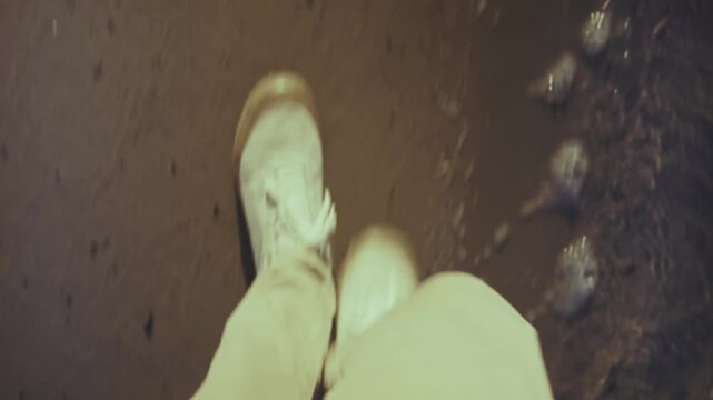 Traveler Walking On Wet Sand Near River Bank. Person Strolling Along Water Edge
