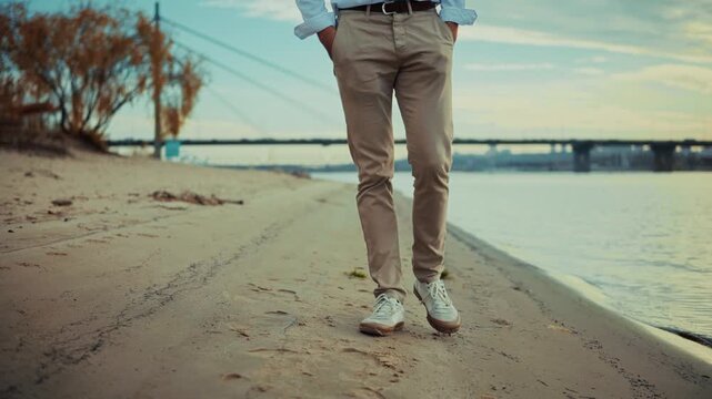 Businessman Walking Along Sandy Riverbank. Casual Walk In Nature. Freedom and Reflection