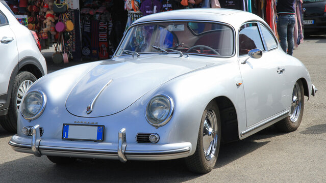 April 9, 2023. Florence, Italy. Vintage silver Porsche 356 sports car parked on the street. Classic German automotive engineering and retro design.