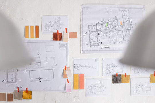 Soft lighting highlighting texture, pinup wall showing plans and swatches clipped with orange clips
