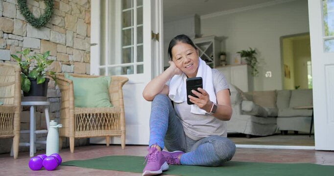 Senior woman tapping smartphone on mat starting animated fitness stats tracking progress