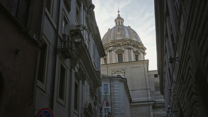Stone church dome above narrow cobbled street with lantern and italian flag hanging from facade  historic calm. © Krakenimages.com