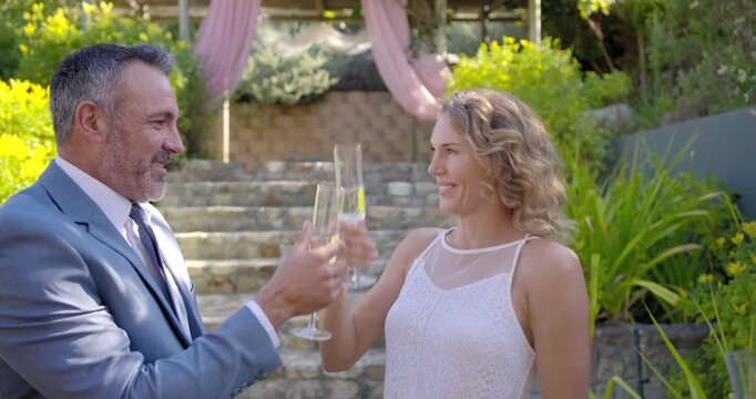 Four friends celebrating, couple hugging, kissing cheek and toasting with flutes at base of steps
