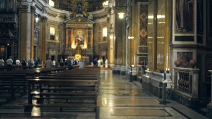 Fototapeta premium Ornate church interior in soft defocused bokeh with blurred pews, aisle and altar; background backdrop copyspace.