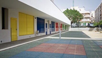 Colorful row of shuttered doors and rubber tile forecourt in soft defocused outdoor background  background backdrop copyspace calm. © Krakenimages.com