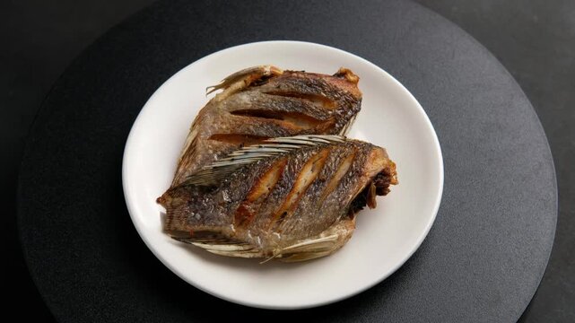 Fried Sun dried tilapia fish in a plate.